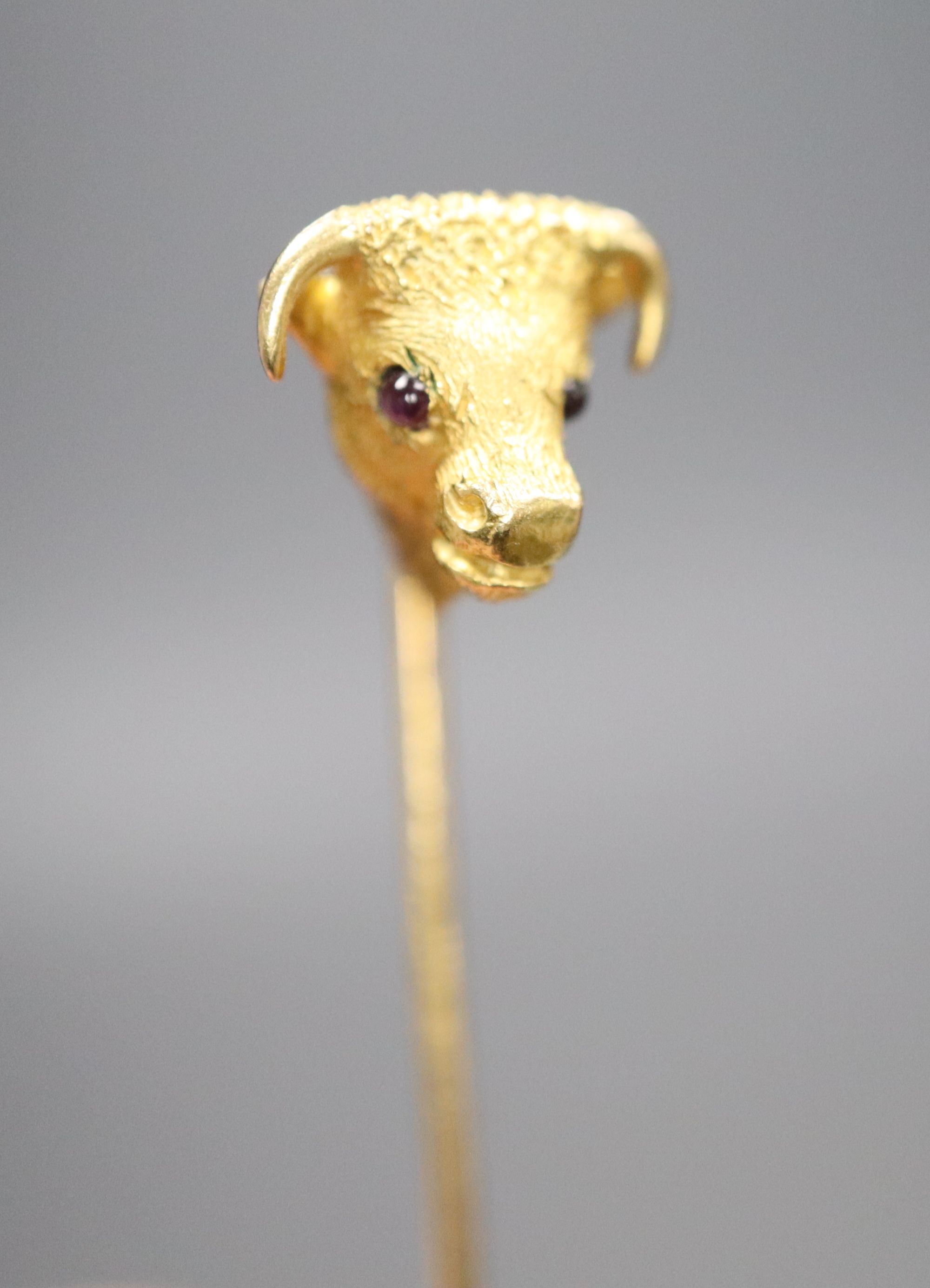 An Edwardian yellow metal and garnet set bulls head stick pin, 65mm, gross 4.4 grams.